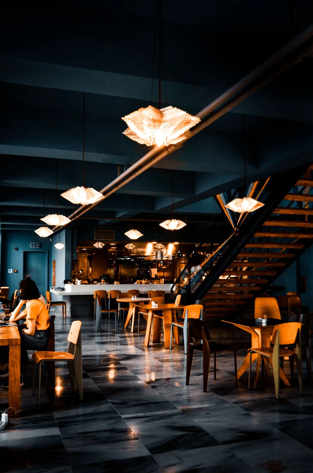 Workspace breakout area with a café bench, soft seating, planting and pendant lighting
