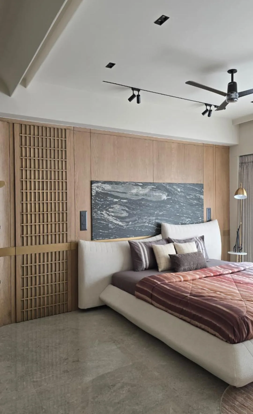 Master bedroom with an upholstered platform bed, a marble headboard panel and oak lattice wardrobe shutters