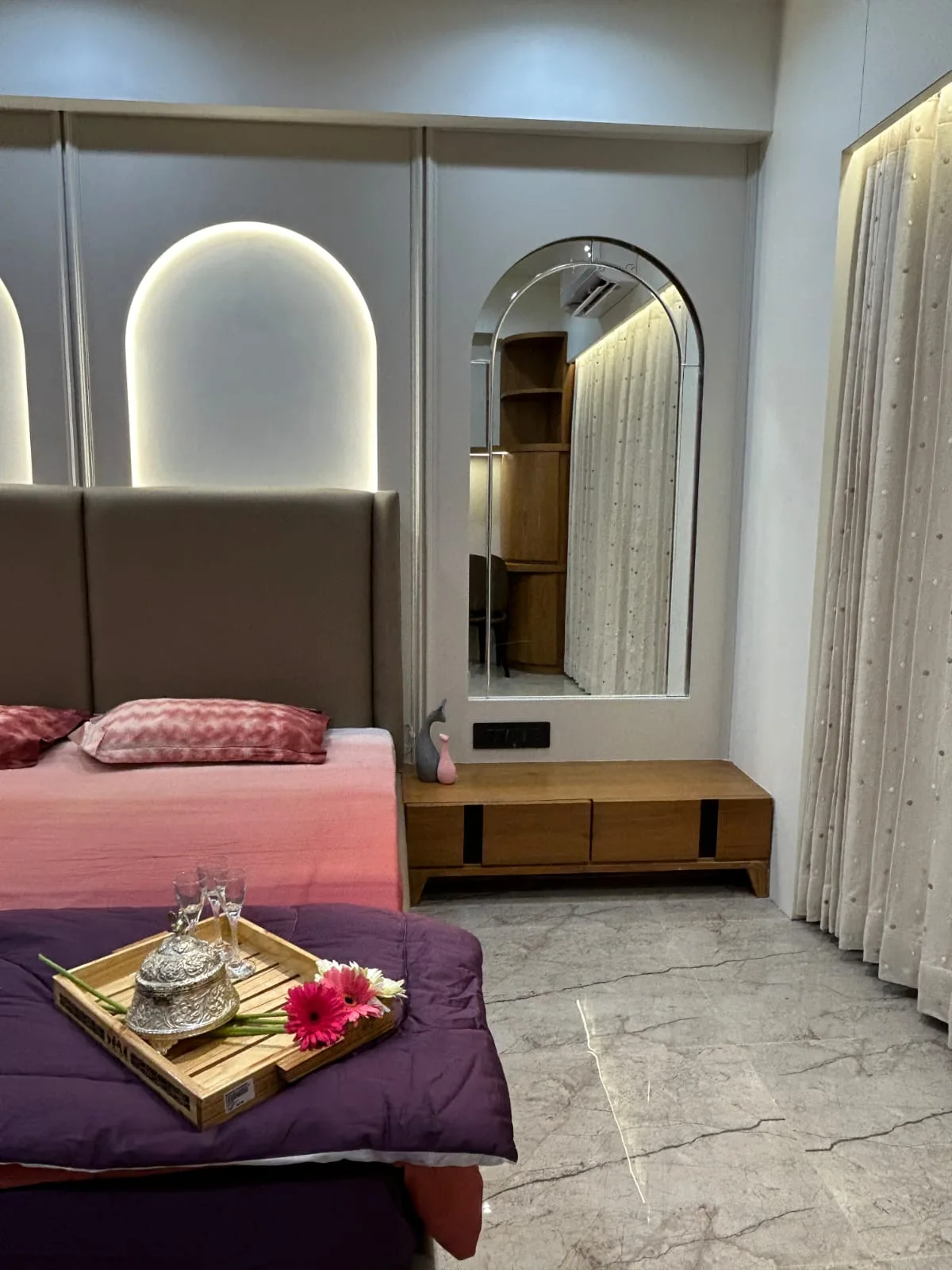 Finished master bedroom with arch mirror and dresser, delivered as part of a turnkey handover