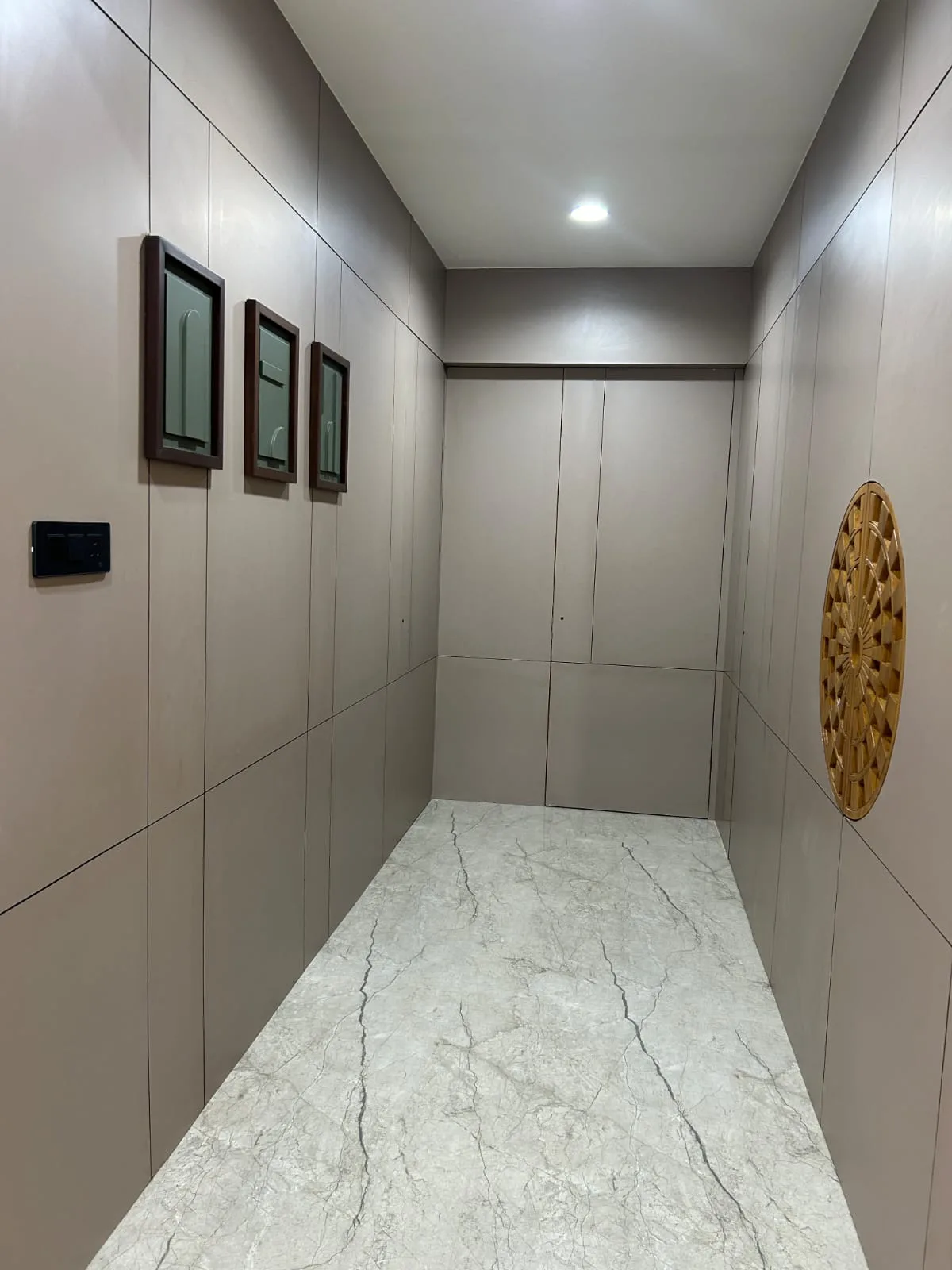 Clinic corridor with panelled storage, a seamless floor and coved skirting at the wall junction
