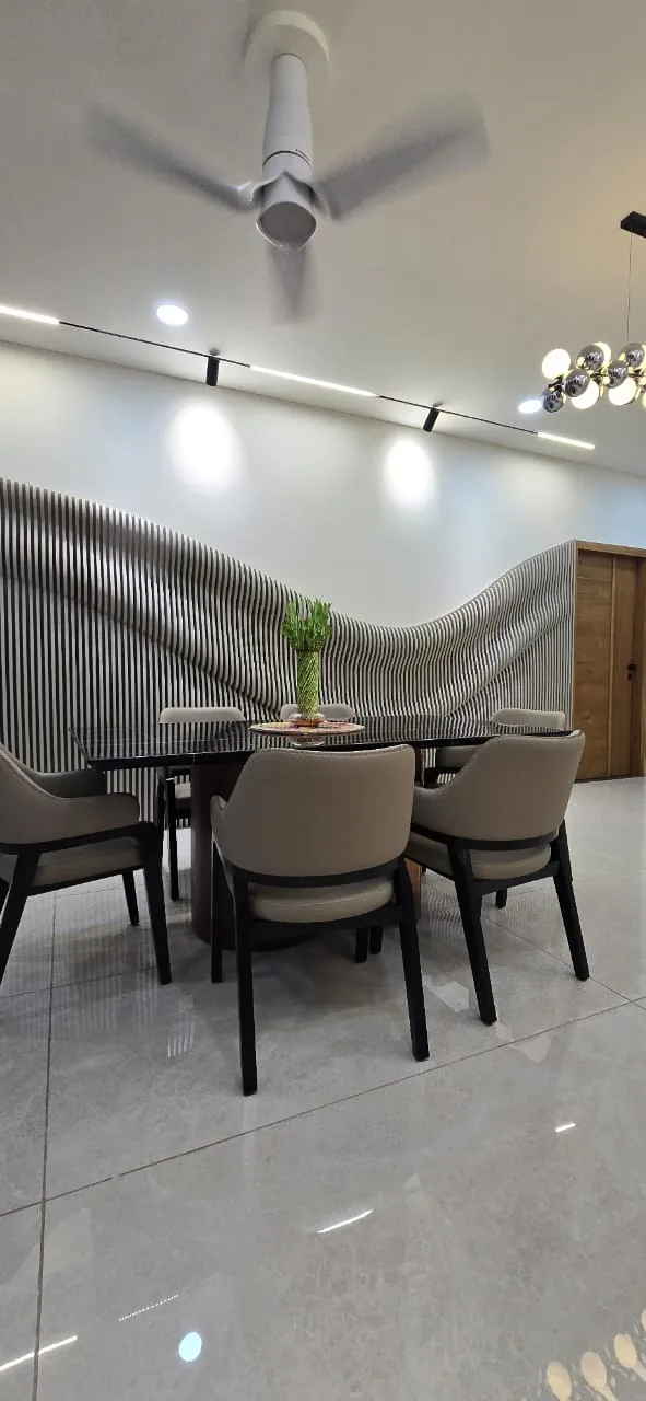 Dining table under a chrome cluster pendant with magnetic track lighting overhead
