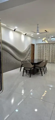 Dining area with a sculpted wave-form fluted feature wall and a stone-topped table