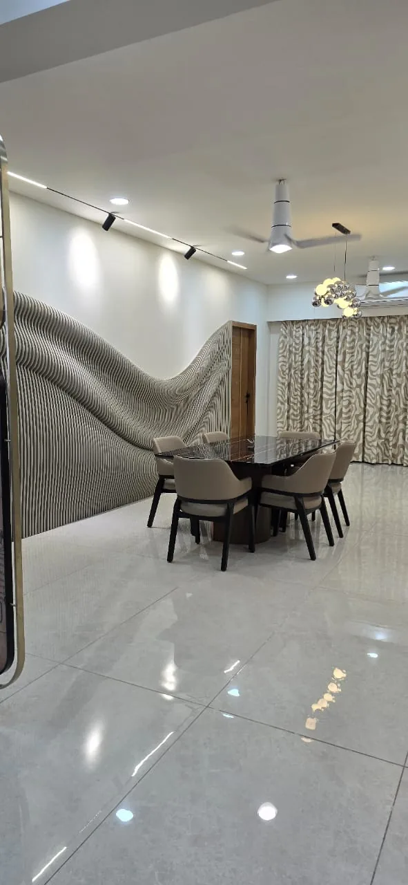 Dining area with a sculpted wave-form fluted feature wall in a 4 BHK apartment in Ahmedabad