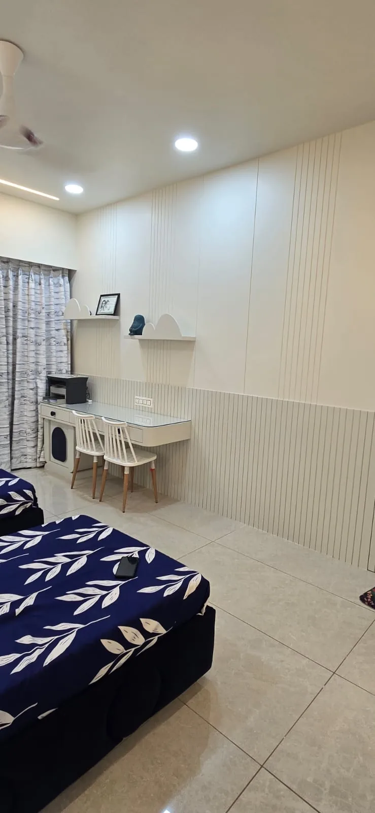 Children’s room with a fluted white wardrobe wall and a wall-hung twin study desk