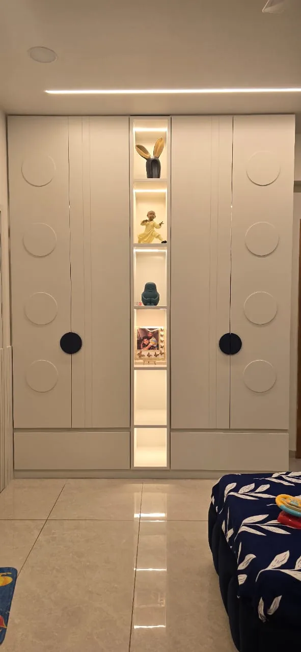Children’s wardrobe with circle-motif shutters and a lit open display niche between them