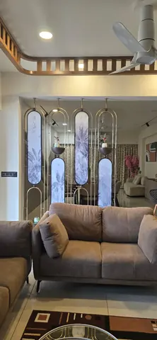 Living room divided from the dining area by brass-framed arched glass screens