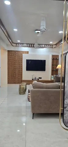 Living room TV wall with a veneered console and a full-height wooden grid screen alongside
